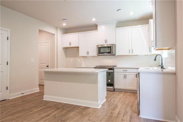 138 Henley St, Canton, GA 30114 - kitchen with stainless steel appliances, light wood-style flooring, white cabinetry, a sink, and recessed lighting