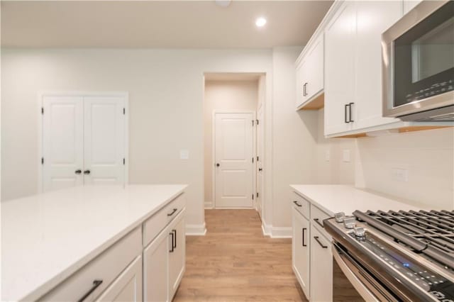 138 Henley St, Canton, GA 30114 - kitchen featuring stainless steel microwave, light wood-type flooring, white cabinetry, recessed lighting, and light countertops