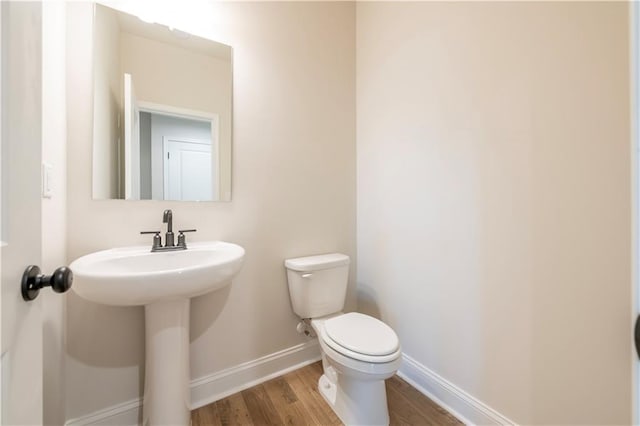 138 Henley St, Canton, GA 30114 - half bathroom featuring toilet, baseboards, and wood finished floors