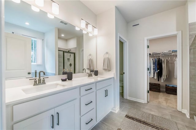 138 Henley St, Canton, GA 30114 - full bath with double vanity, a stall shower, a spacious closet, toilet, and baseboards