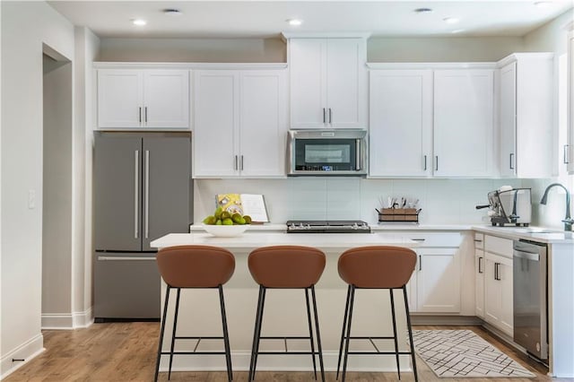 138 Henley St, Canton, GA 30114 - kitchen with stainless steel appliances, a kitchen island, a sink, white cabinetry, and a breakfast bar