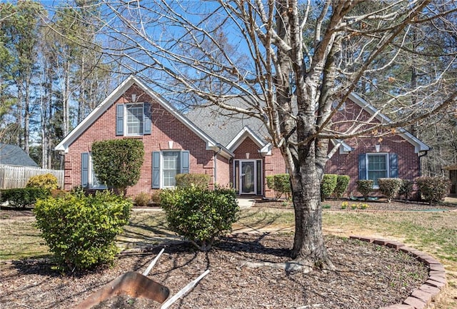 view of front of home featuring fence and brick siding