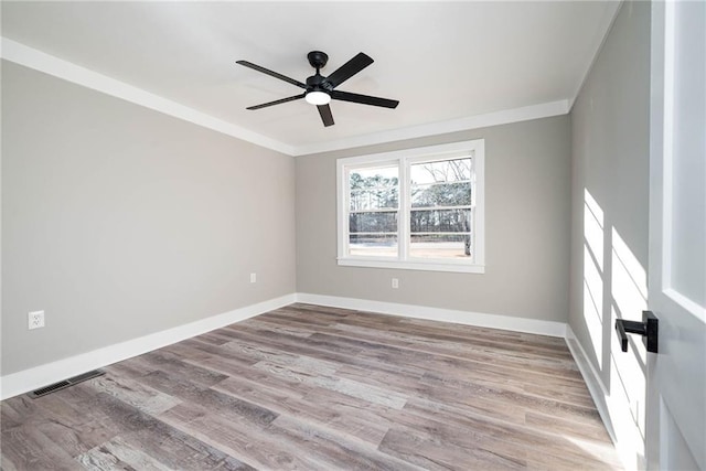 unfurnished room with ceiling fan, visible vents, wood finished floors, baseboards, and ornamental molding