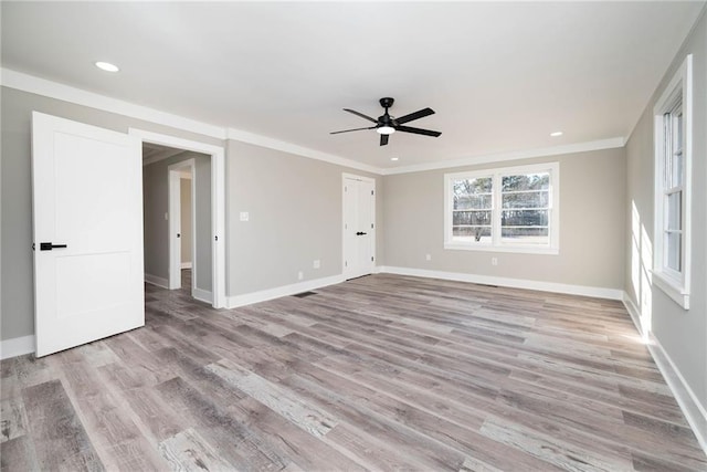 empty room featuring baseboards, a ceiling fan, light wood-style flooring, and crown molding