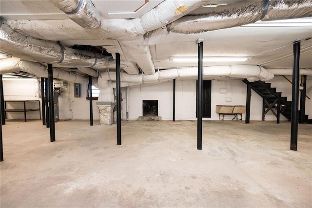 below grade area with water heater, stairway, and electric panel