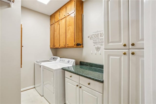 washroom featuring washer and dryer, cabinet space, and baseboards