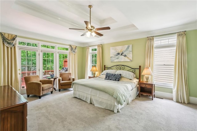 bedroom with a tray ceiling, crown molding, access to exterior, a ceiling fan, and carpet floors