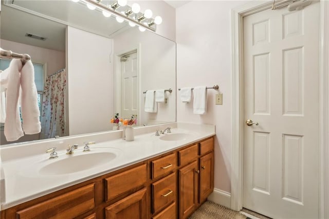 full bathroom featuring double vanity, visible vents, and a sink