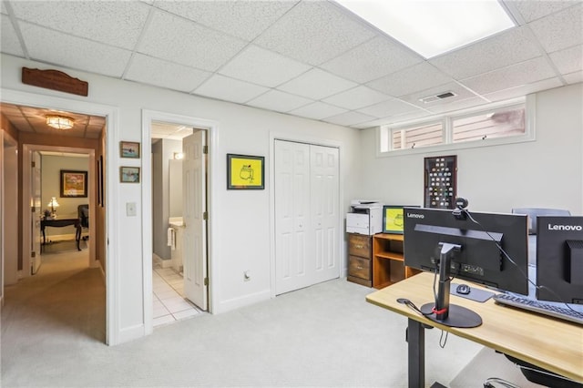 office space with a paneled ceiling, visible vents, carpet floors, and baseboards