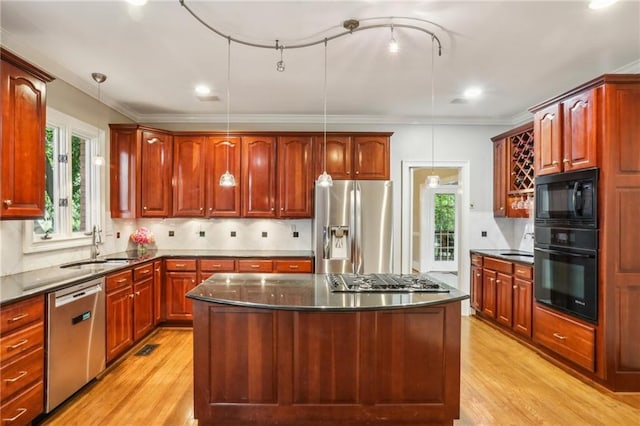 kitchen with black appliances, a wealth of natural light, and light wood-style flooring