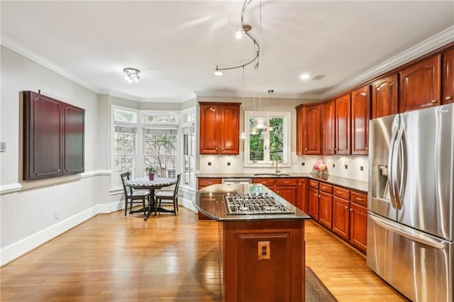 kitchen featuring light wood-type flooring, stainless steel appliances, dark countertops, and plenty of natural light