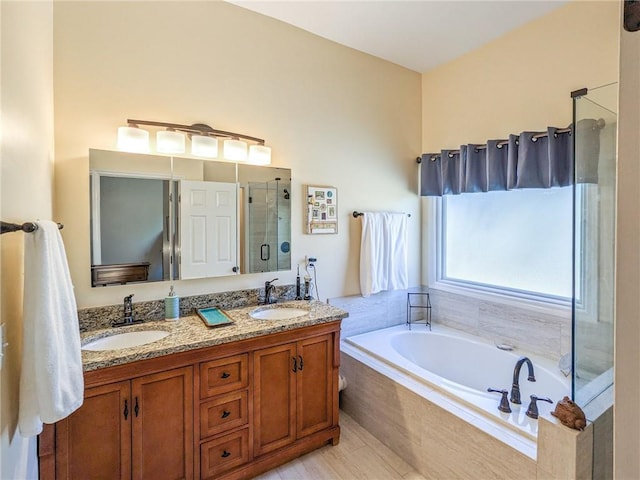 bathroom with a sink, double vanity, a bath, and a shower stall