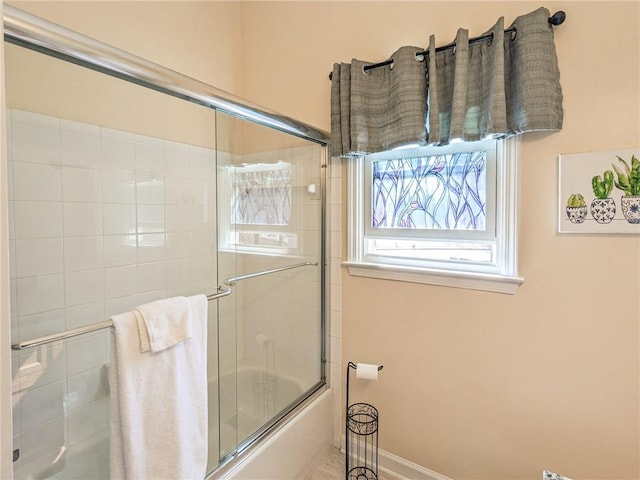 bathroom with shower / bath combination with glass door