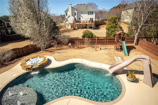 view of pool featuring a playground, a fenced backyard, and a water slide