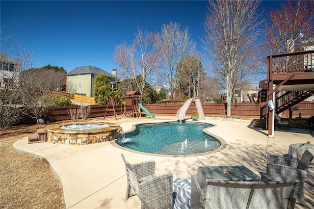 view of pool featuring stairway, a water slide, a fenced backyard, a playground, and a patio area