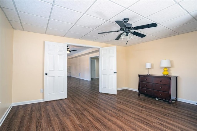 interior space featuring a paneled ceiling, wood finished floors, baseboards, and ceiling fan