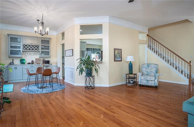 dining room with baseboards, stairs, ornamental molding, an inviting chandelier, and wood finished floors