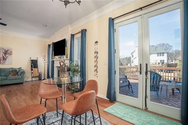 dining room featuring crown molding, wood finished floors, baseboards, and french doors