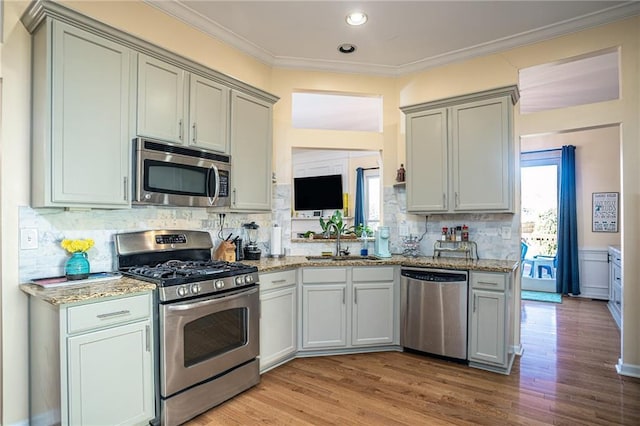 kitchen featuring crown molding, a wealth of natural light, appliances with stainless steel finishes, and a sink