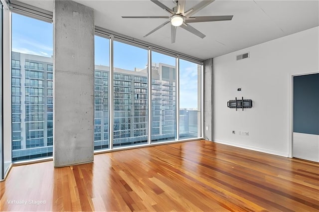 855 Peachtree St NE Unit 2713, Atlanta, GA 30308 - empty room featuring a ceiling fan, a wealth of natural light, expansive windows, and wood finished floors