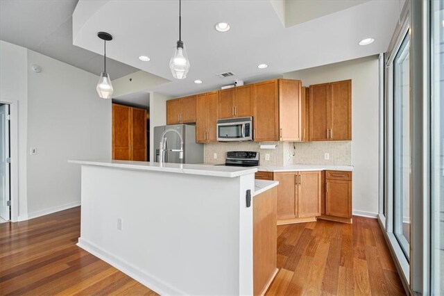 855 Peachtree St NE Unit 2713, Atlanta, GA 30308 - kitchen with visible vents, decorative backsplash, light countertops, dark wood finished floors, and appliances with stainless steel finishes
