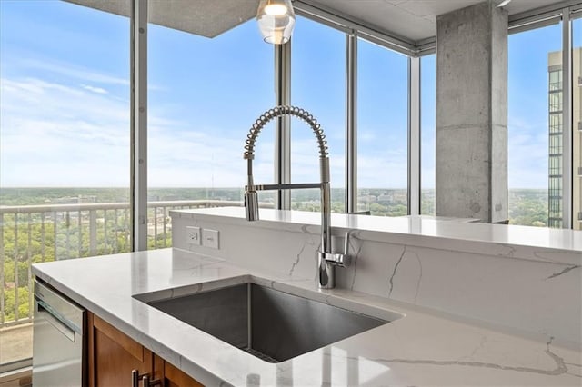 855 Peachtree St NE Unit 2713, Atlanta, GA 30308 - kitchen featuring plenty of natural light, brown cabinets, dishwasher, a sink, and light stone counters