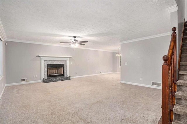 unfurnished living room with a fireplace with raised hearth, stairway, ceiling fan with notable chandelier, and visible vents