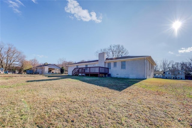 back of property with a deck and a lawn