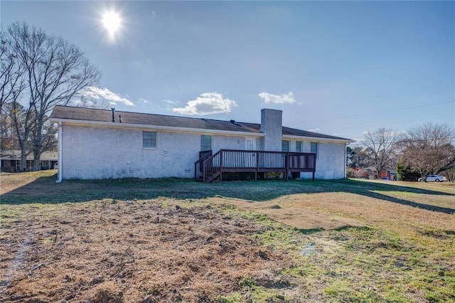 rear view of property featuring a wooden deck and a yard