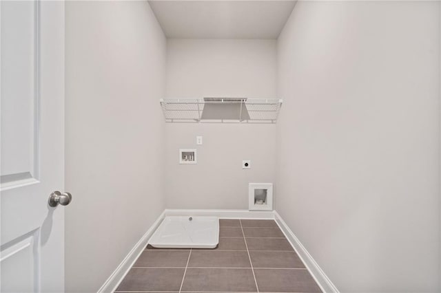 clothes washing area featuring hookup for an electric dryer, dark tile patterned floors, and hookup for a washing machine