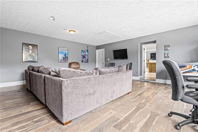 living room with light hardwood / wood-style floors and a textured ceiling