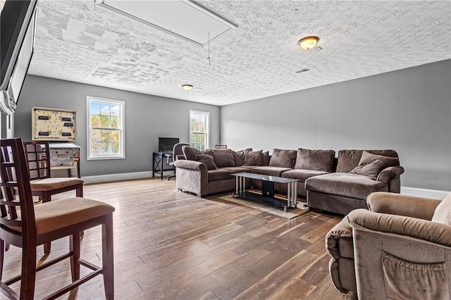 living room with dark wood-type flooring and a textured ceiling