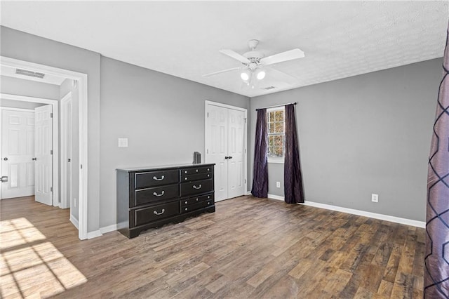 unfurnished bedroom featuring ceiling fan, dark hardwood / wood-style floors, and a closet