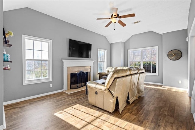 living room featuring a tile fireplace, hardwood / wood-style flooring, ceiling fan, and lofted ceiling