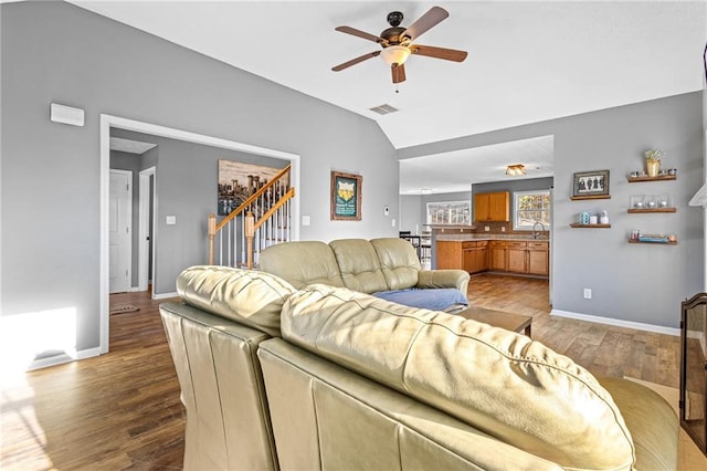 living room featuring ceiling fan, sink, vaulted ceiling, and light wood-type flooring