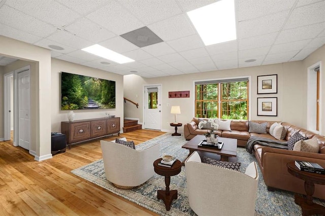 living room featuring a paneled ceiling and light wood-type flooring