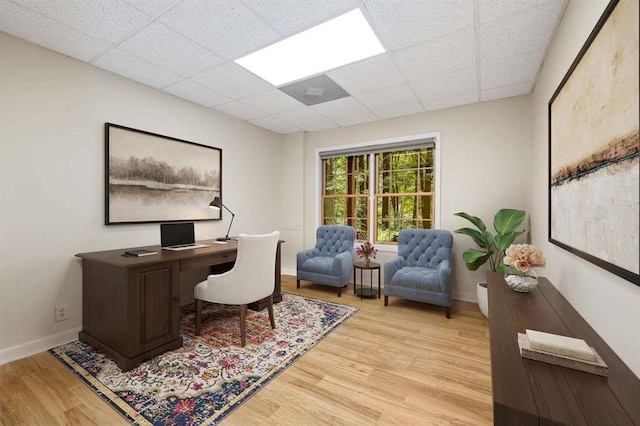 office with light hardwood / wood-style floors and a paneled ceiling