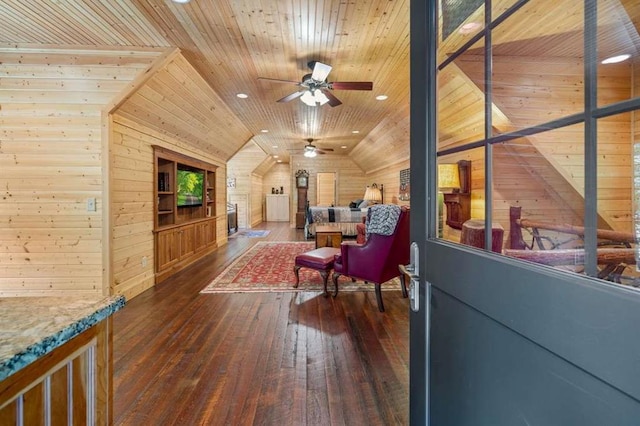 sitting room featuring dark wood-type flooring, wooden walls, lofted ceiling, ceiling fan, and wooden ceiling