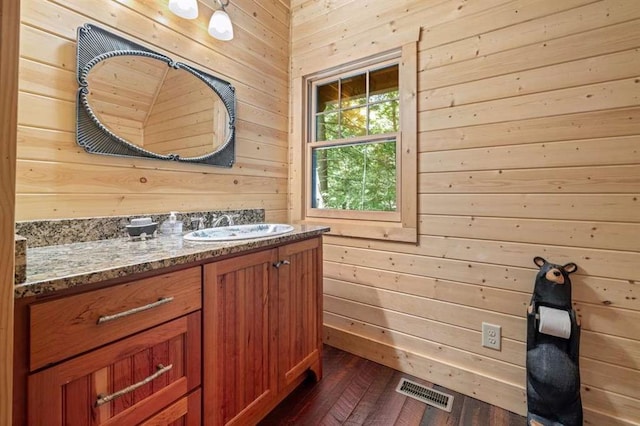 bathroom with vanity, wood walls, and hardwood / wood-style flooring