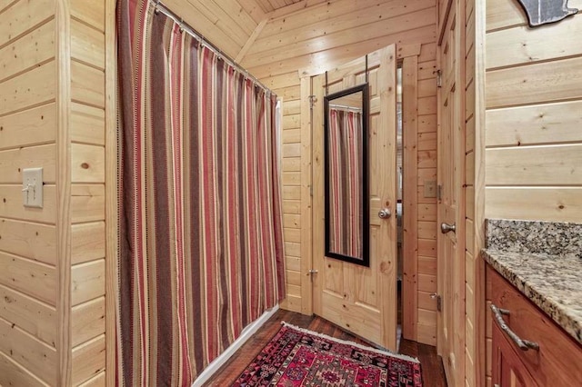 interior space with wooden ceiling, wood walls, and dark wood-type flooring