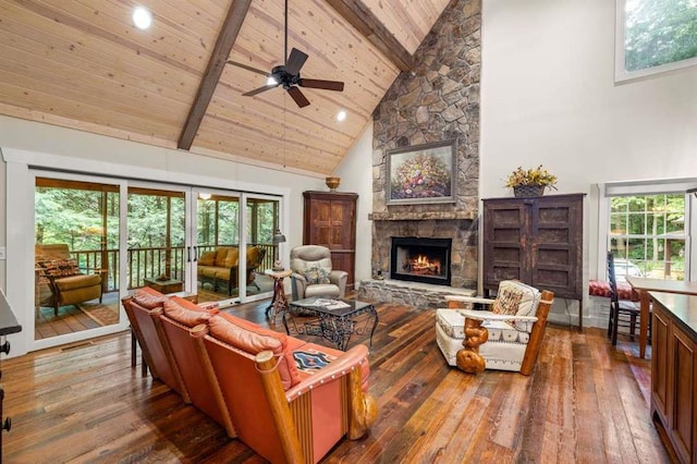 living room with wood ceiling, high vaulted ceiling, beamed ceiling, and a stone fireplace