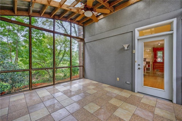 unfurnished sunroom featuring ceiling fan