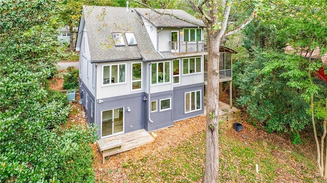 rear view of property with a balcony and central AC