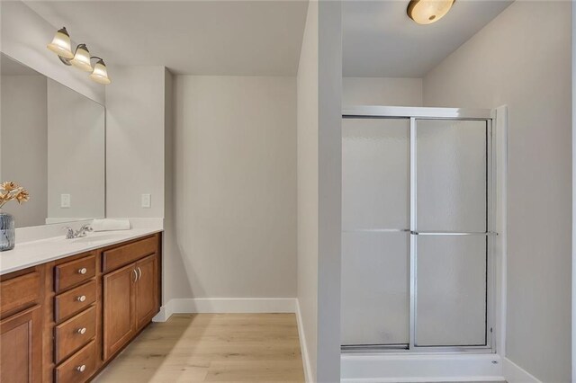 506 Tallapoosa Trl, Woodstock, GA 30188 - bathroom featuring baseboards, a shower with door, wood finished floors, and vanity