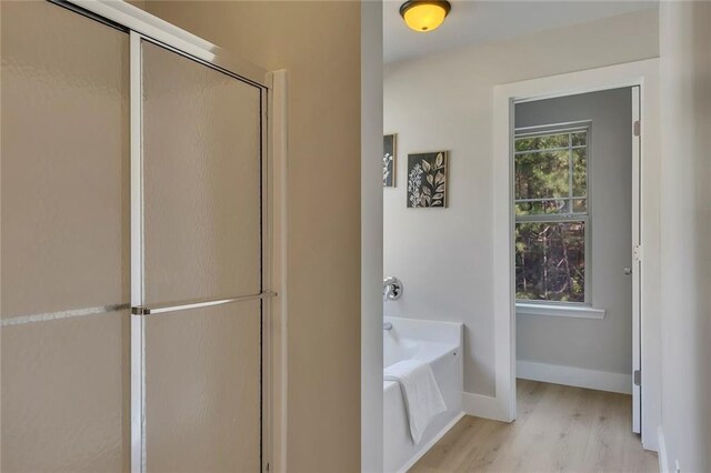 506 Tallapoosa Trl, Woodstock, GA 30188 - full bath with baseboards, a shower with shower door, a bath, and wood finished floors