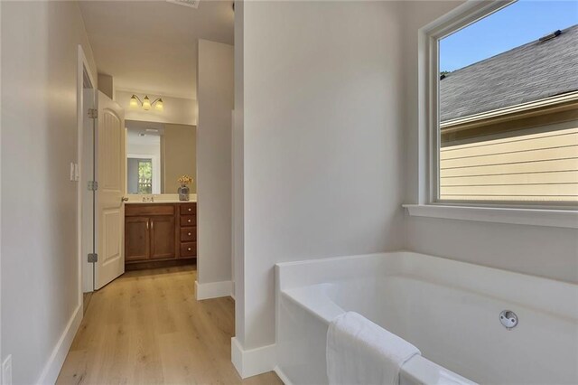 506 Tallapoosa Trl, Woodstock, GA 30188 - full bath with a wealth of natural light, vanity, a bath, and wood finished floors