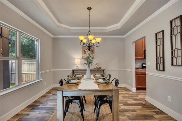 506 Tallapoosa Trl, Woodstock, GA 30188 - dining space with a notable chandelier, baseboards, crown molding, dark wood-type flooring, and a raised ceiling
