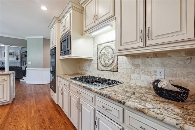 kitchen with tasteful backsplash, wood-type flooring, stainless steel appliances, light stone countertops, and crown molding