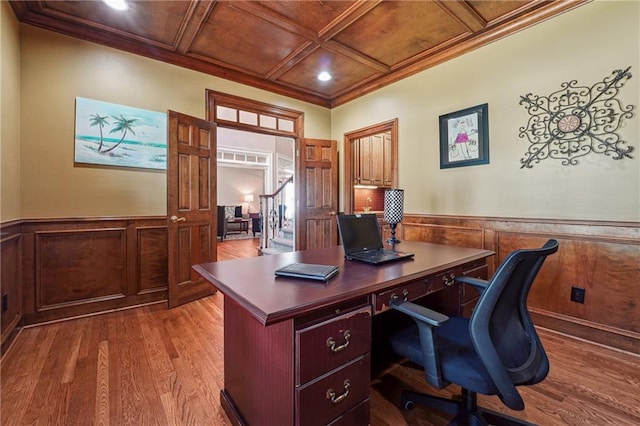 home office with light wood-type flooring, coffered ceiling, wooden ceiling, and crown molding