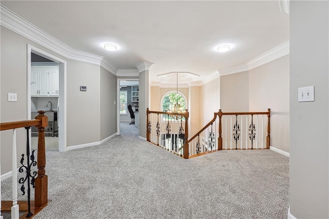 hall featuring carpet flooring, crown molding, and a chandelier